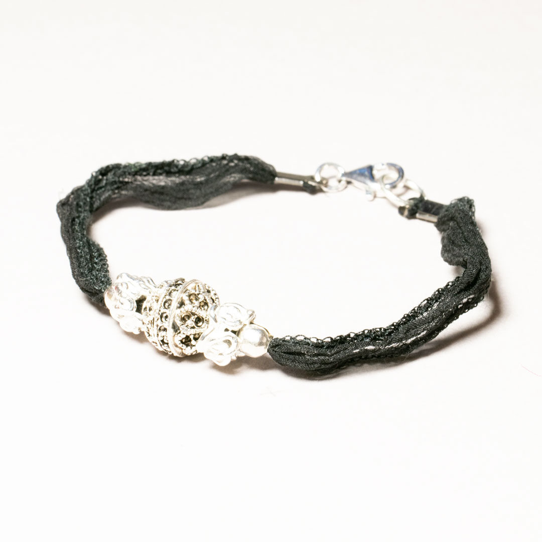 armband av silverkula och sidenband