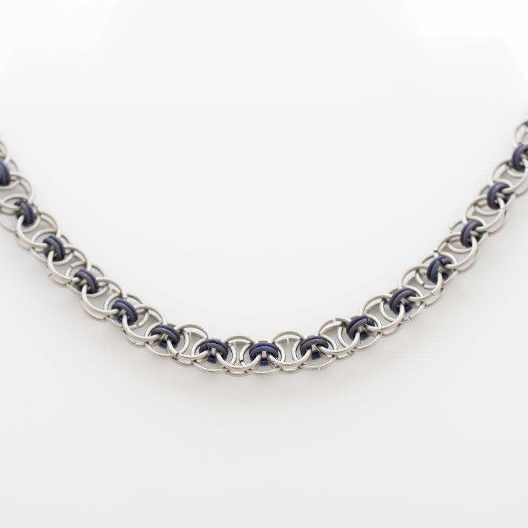 halsband av grå och lila titanringar